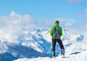 Skier gazing at a majestic snow-covered mountain