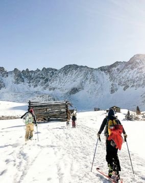 Group of skiers walking on snow-covered terrain, preparing for their skiing adventure